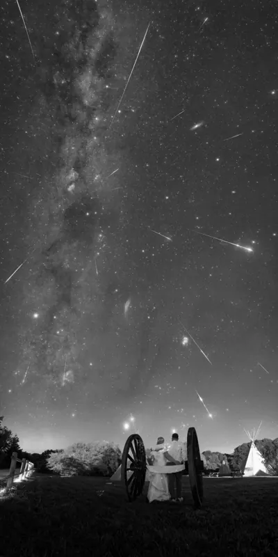 Les mariés sous une pluie d’étoiles, au pied d’une arche en bois.