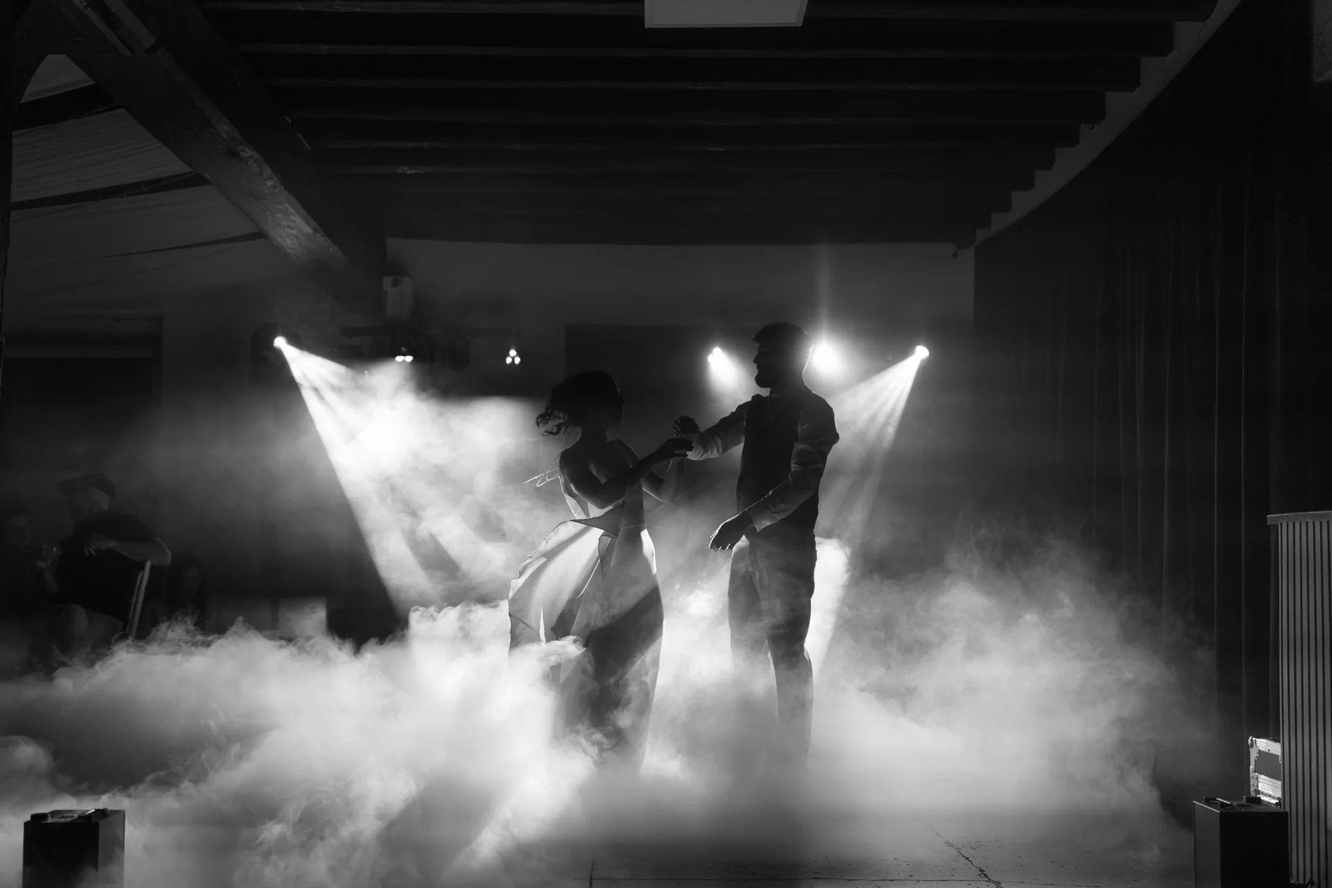 Les mariés enlacés pour leur première danse, entre brume et lumière.