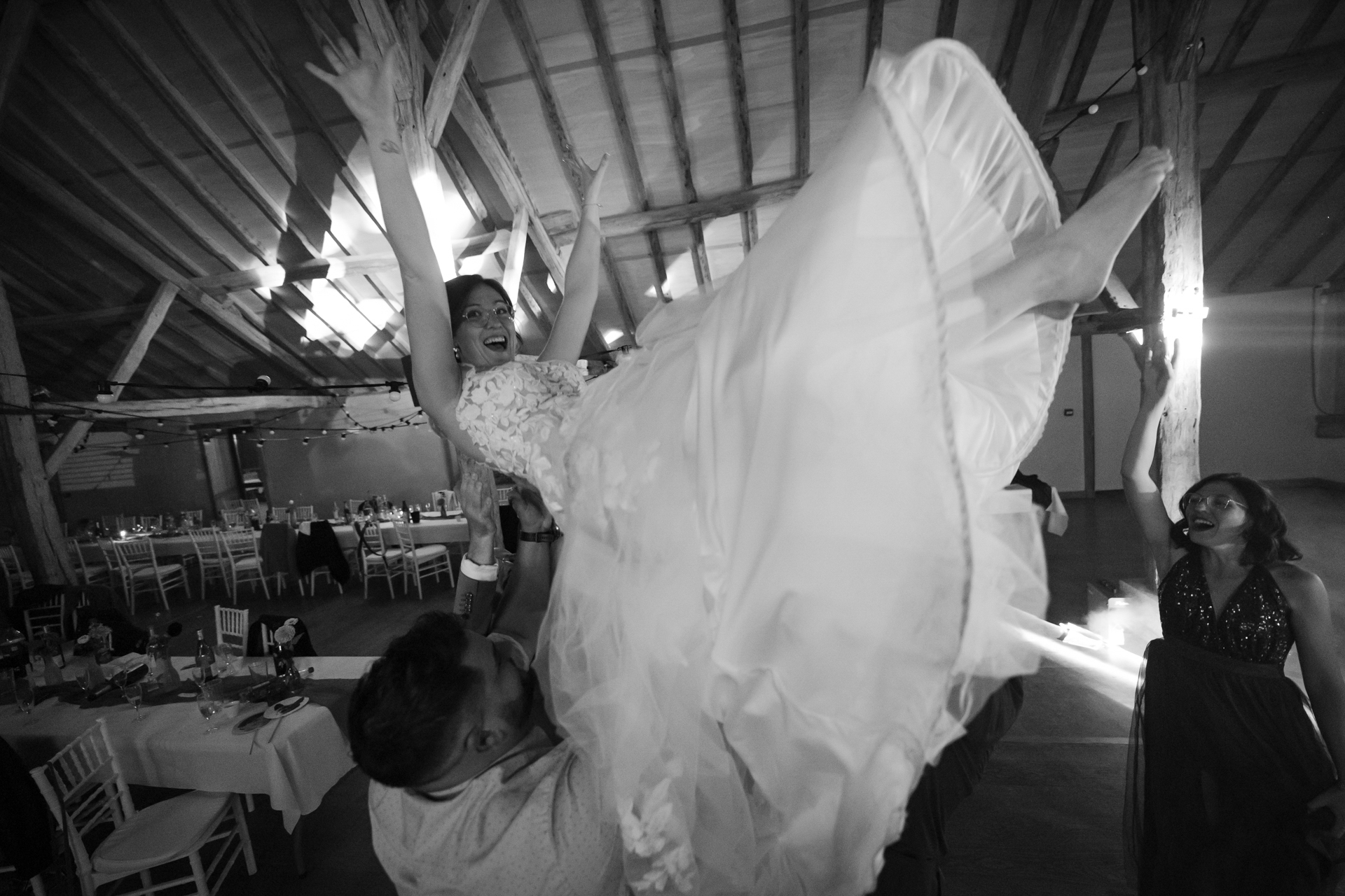 La mariée portée par ses proches, les bras levés et le sourire aux lèvres pendant la soirée dansante.