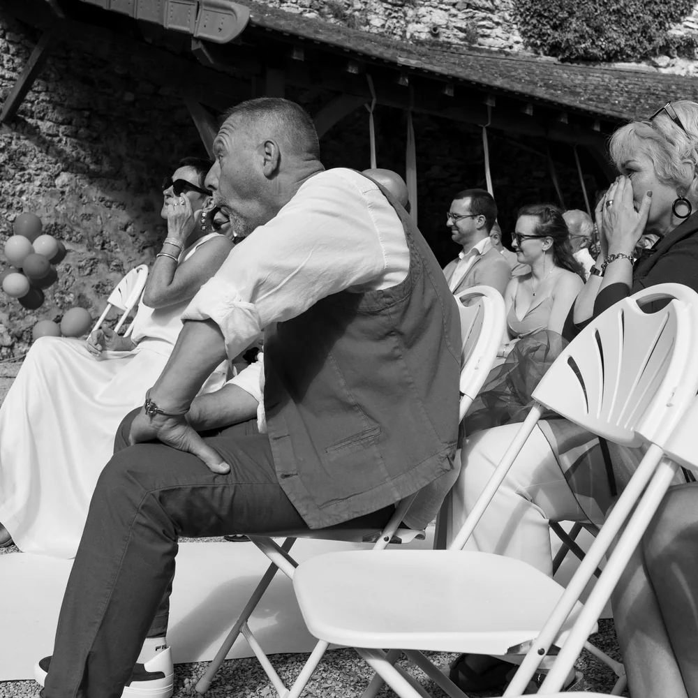Les mariés émus pendant leur cérémonie de mariage, entourés de leurs proches.