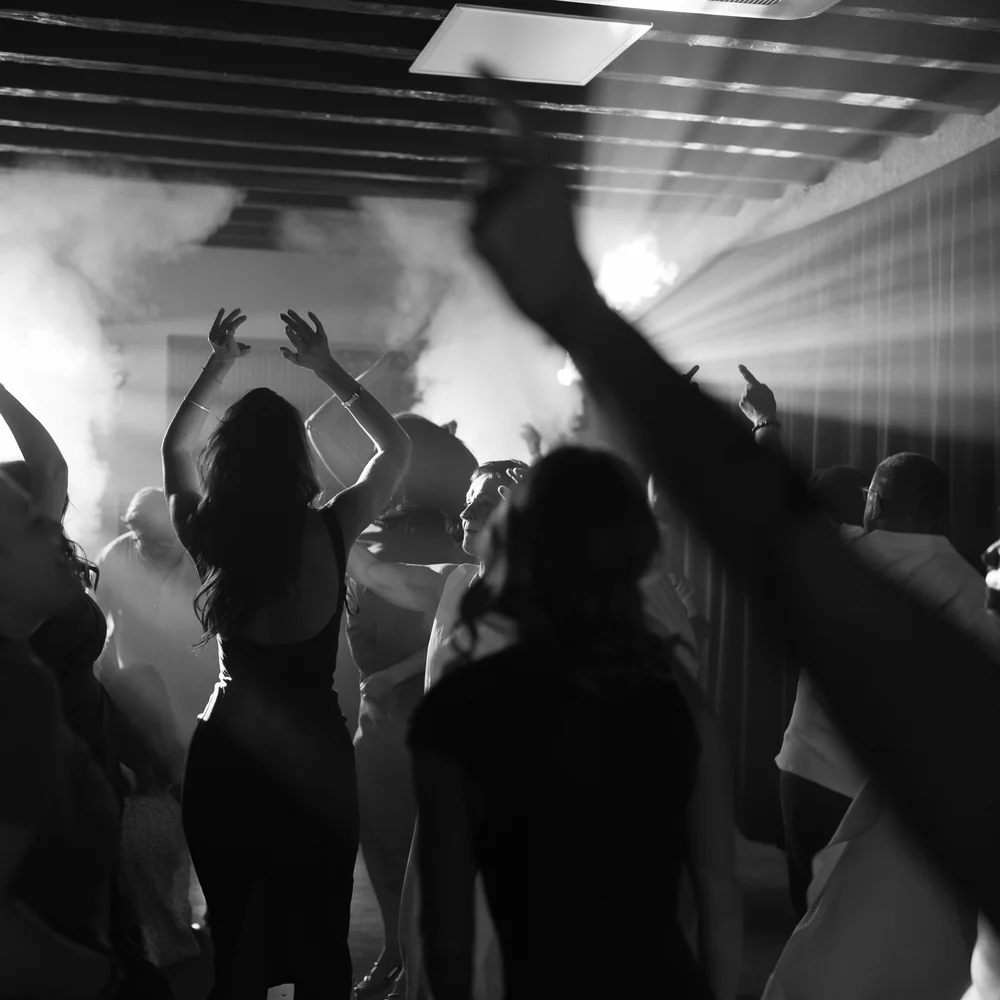 Les invités dansent les bras levés sur la piste de danse pendant la fête de mariage.